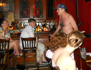 Shirtless Paul bounds into the bar audience.