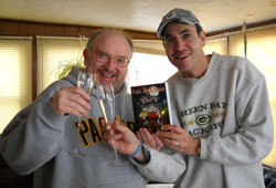Clad in Green Bay Packers wear, publisher Steve Sullivan and Paul toast.